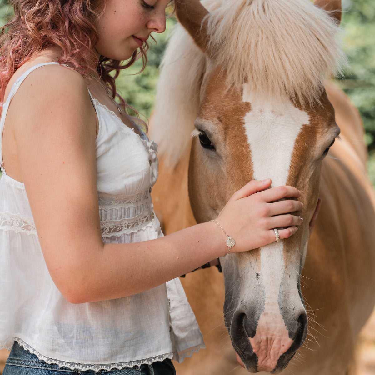 Sfeerfoto van een meisje met haar paard, symbool voor de diepe band die kan worden vereeuwigd in een persoonlijk juweel met afdruk