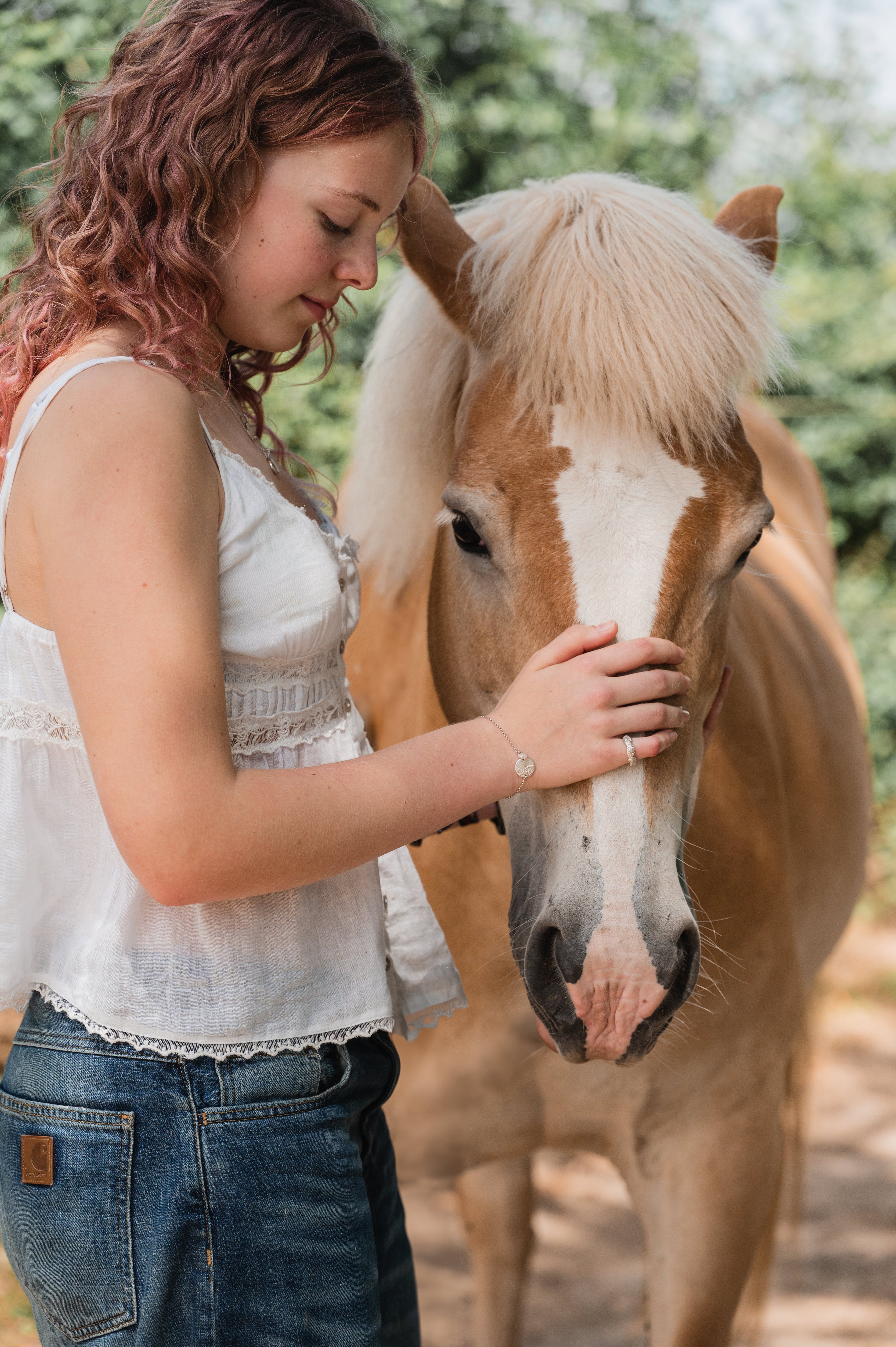 Sfeerfoto van een meisje met haar paard, symbool voor de diepe band die kan worden vereeuwigd in een persoonlijk juweel met afdruk