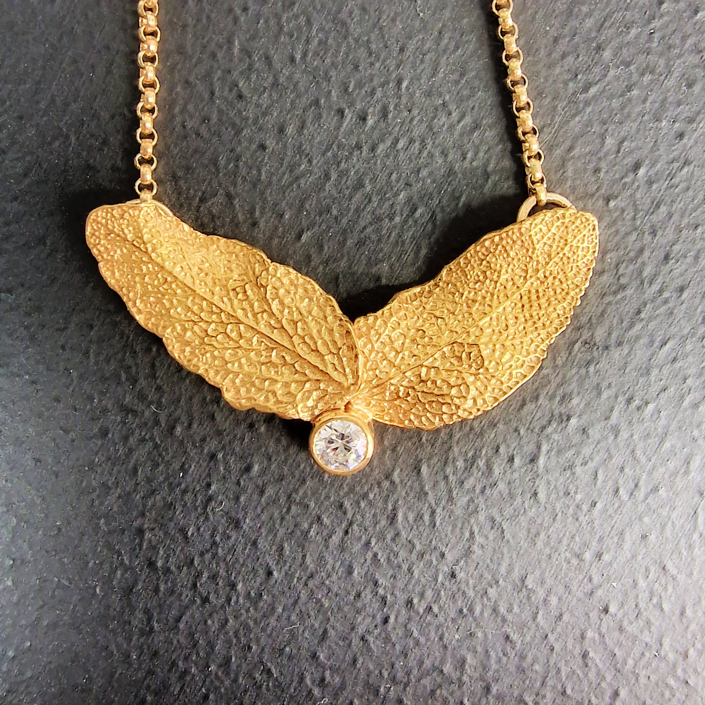 Zilveren hanger met blaadjes met prachtige structuur en swarovski kristal, verguld