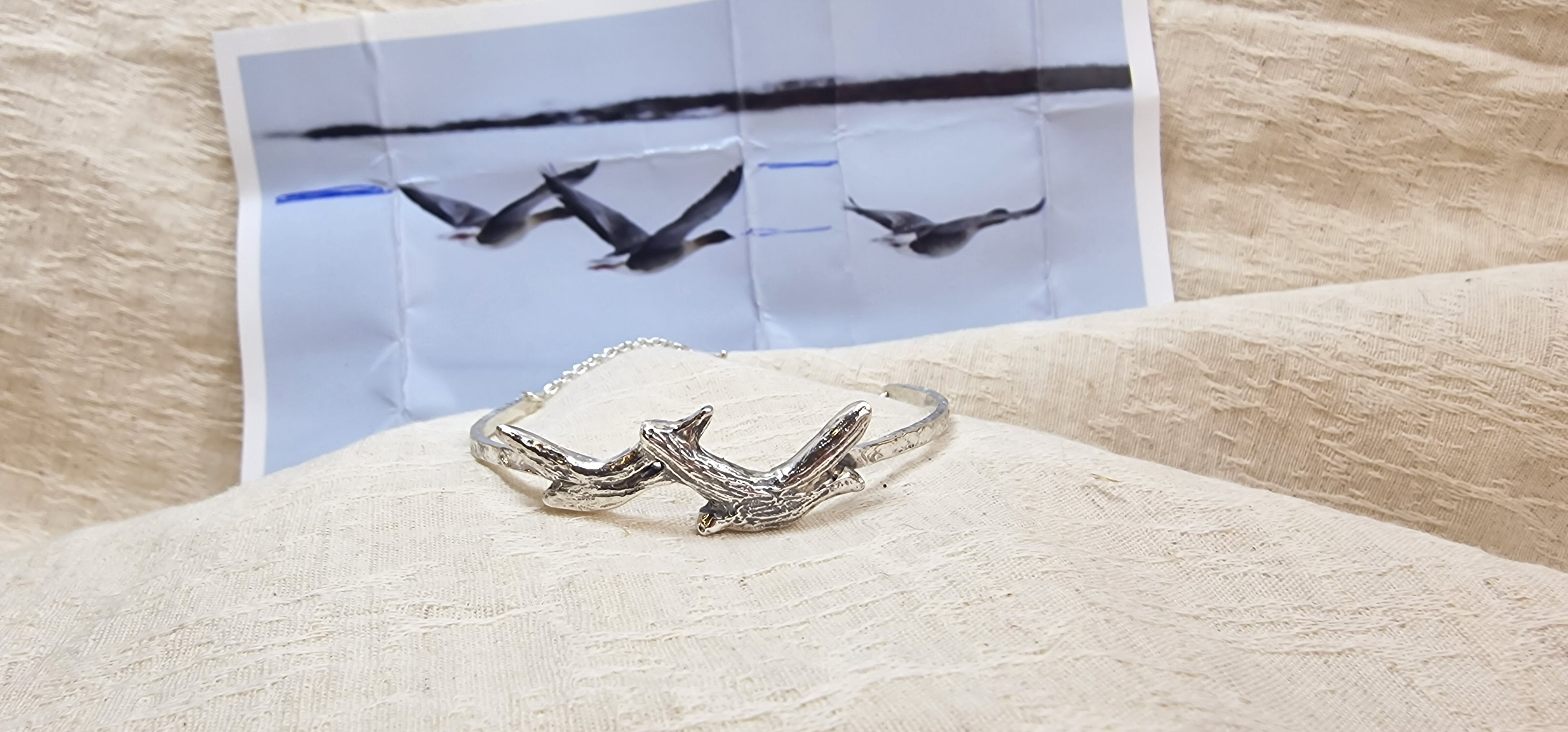 Zilveren armband gemaakt naar foto van de klant met de vliegende vogels. Assen aan de binnenzijde verwerkt