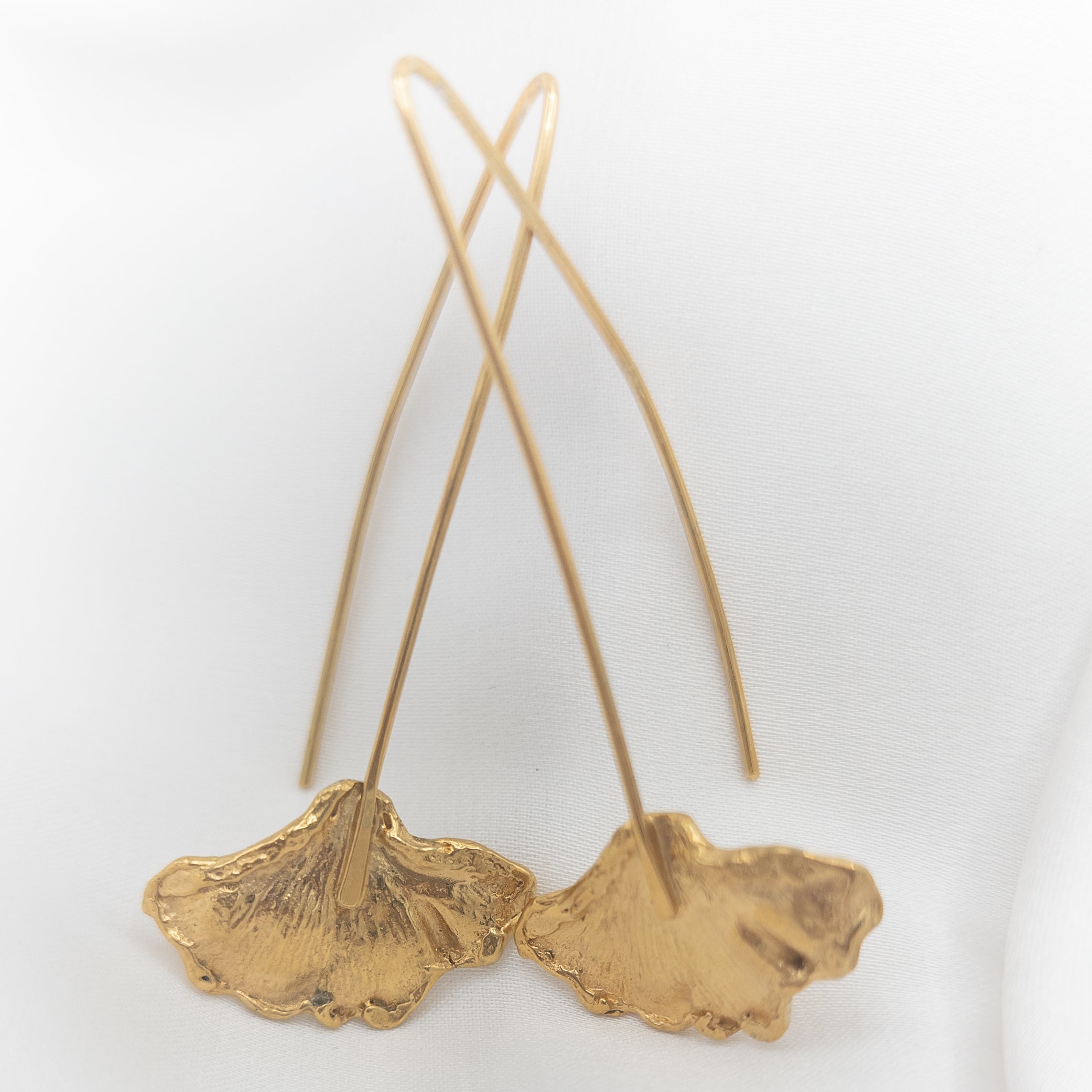 lange gouden oorbellen met aan de onderzijde fijne ginkgo blaadjes
